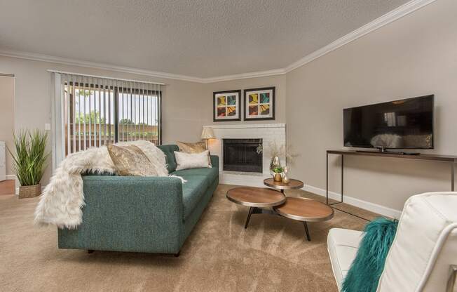 a living room with a blue couch and a fireplace at Lodge of Overland Park Apartments, Overland Park , 66212