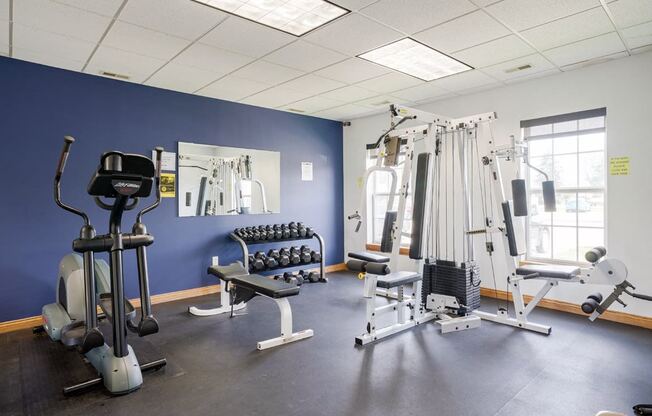 24-hour fitness center with an elliptical, dumbbell weights, and cable machine