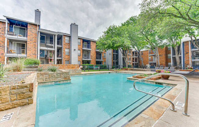 A swimming pool in front of a brick building.