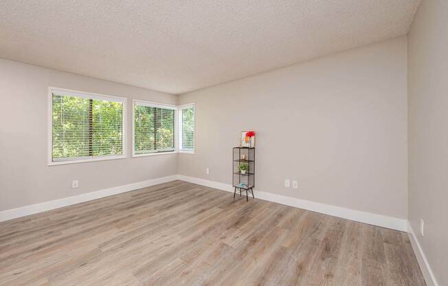 A room with wooden flooring and a window with blinds.