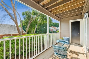 A small balcony with a table and two chairs.