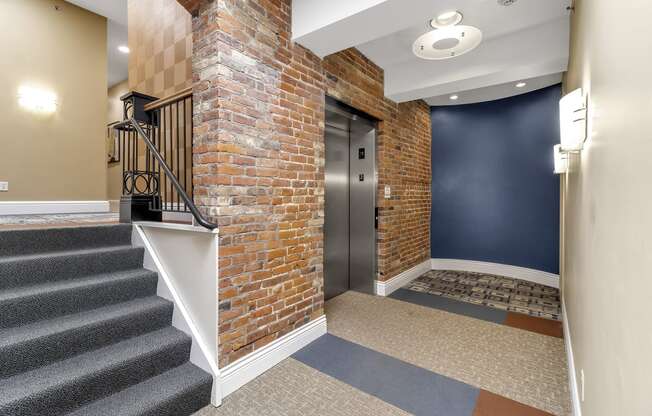 the front door of a building with a brick wall and stairs