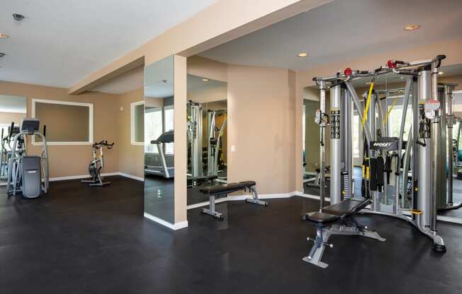 a gym with cardio equipment and weights on the floor