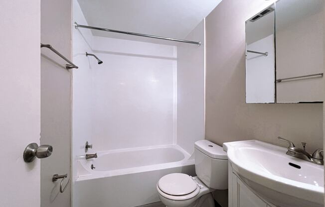 a bathroom with a toilet and a sink and a tub