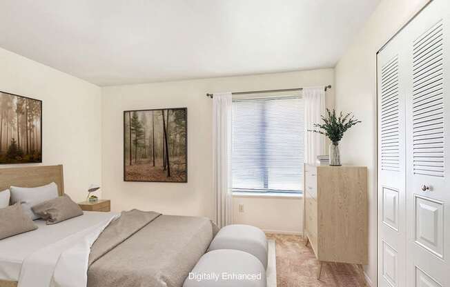 A bedroom with a bed, a nightstand, a cabinet, and a closet at Irish Hills Apartments, South Bend, Indiana