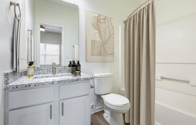 a bathroom with a toilet and a shower and a sink