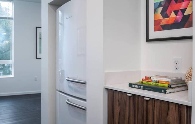 a kitchen with a refrigerator and a counter with books