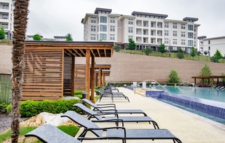 relaxing poolside lounging area at Reveal Skyline apartments