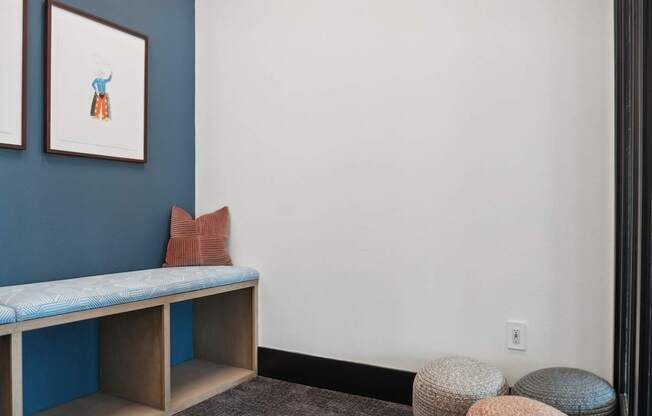 A room with a blue bench and a white wall.