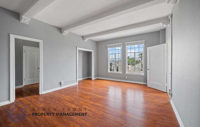 an empty living room with hardwood flooring and a window