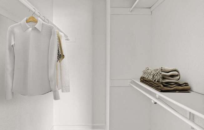 A white shirt hanging on a hanger in a white closet.