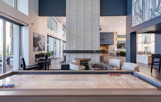 a shuffleboard table in a clubhouse with a fireplace