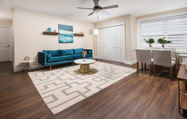 a living room with a blue couch and a dining room table