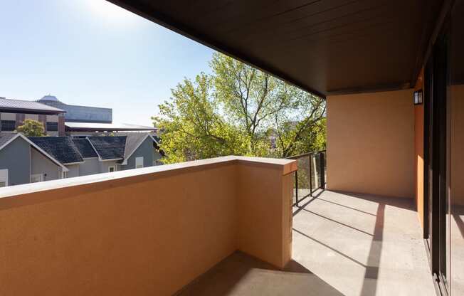 a balcony with a view of a house and a tree