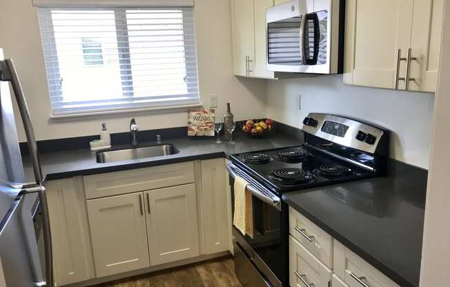 a kitchen with black counter tops and white cabinets