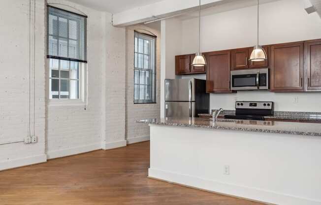 A kitchen with wooden cabinets and a stainless steel refrigerator.