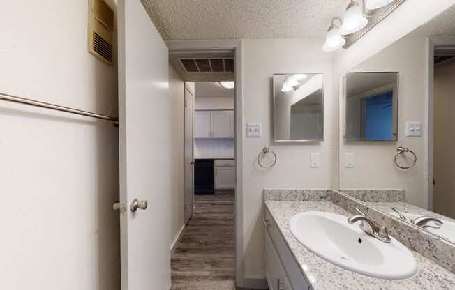 a bathroom with a sink and a mirror and a refrigerator