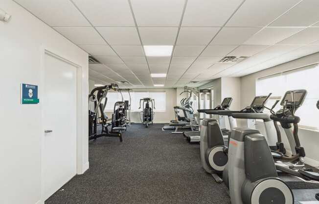 a gym with cardio machines and weights on the floor at The Lafayette Apartments, Colonial Place, Norfolk