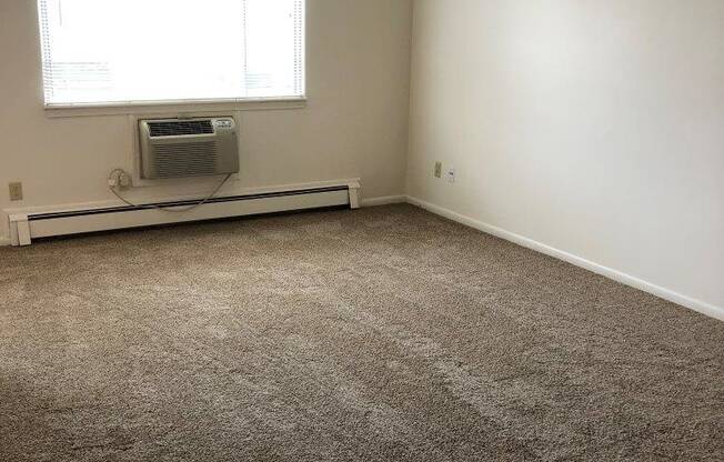 an empty room with a window and a radiator