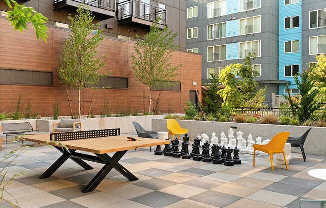 A chess set is set up on a table outside.