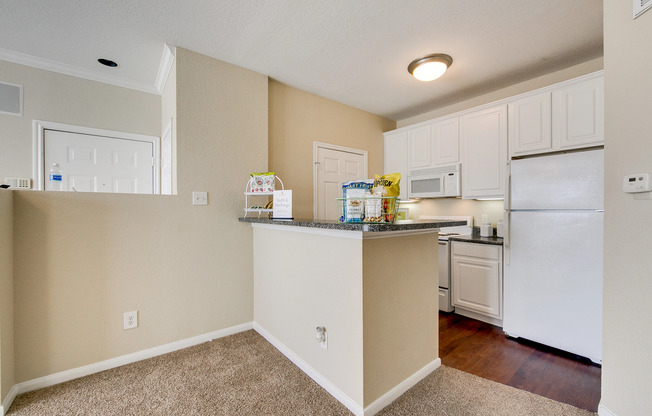 View of Classic Apartment Interior, Showing Kitchen with Plank Wood Flooring and Gas Appliances at Stonebriar of Frisco Apartments