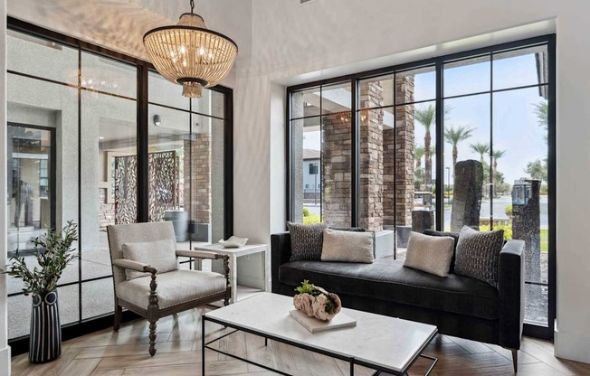 A modern living room with a black couch, a white coffee table, and a large window. at The Laurel Apartments, Chandler, 85286