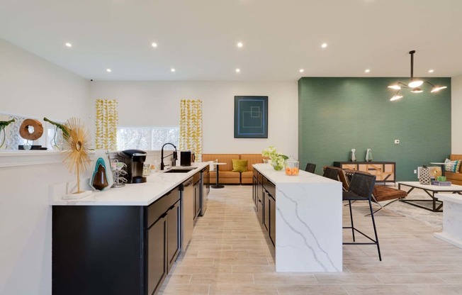 a kitchen with a long counter and a living room in the background at Station JTown, Louisville Kentucky