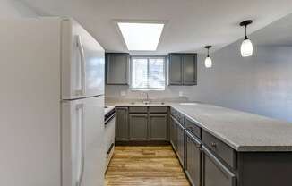 A kitchen with a white refrigerator and wooden floors.