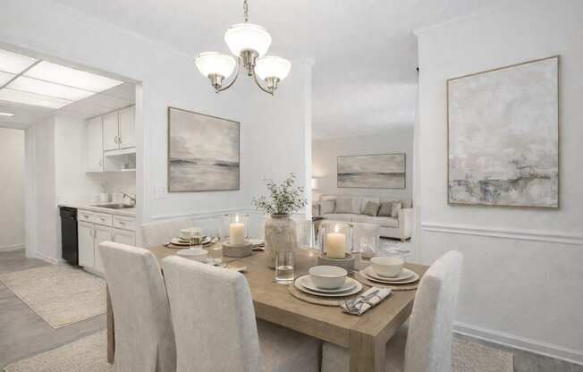 A dining room with a table set for two with candles on the table.