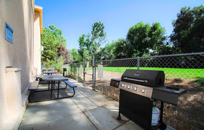 Outdoor barbeque space adjacent and connected to neighboring park space.