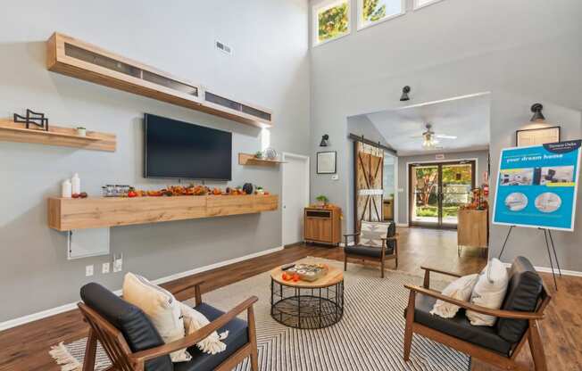 a living room with two chairs and a tv on the wall