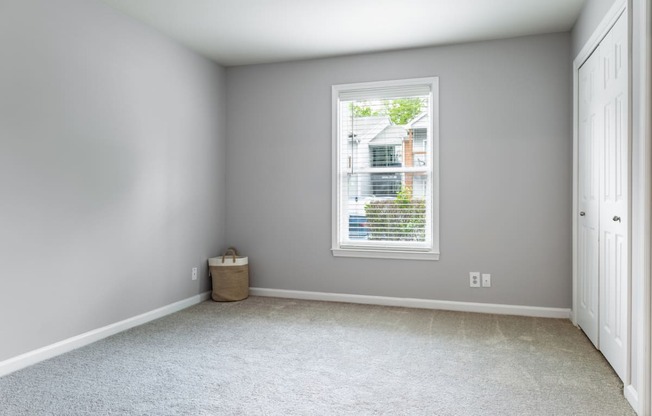 an empty room with a large window and a white door