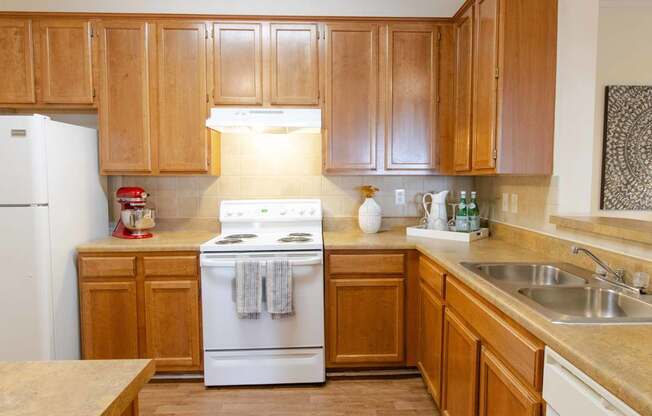 A kitchen with wooden cabinets and a white stove top oven.