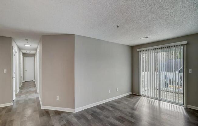 a living room with a sliding glass door to a balcony at The Sapphire, Georgia, 30035