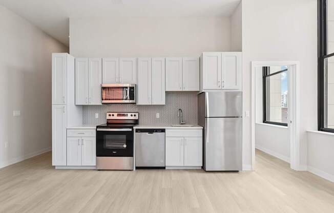A kitchen with white cabinets and stainless steel appliances.