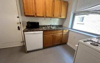 a small kitchen with white appliances and wooden cabinets