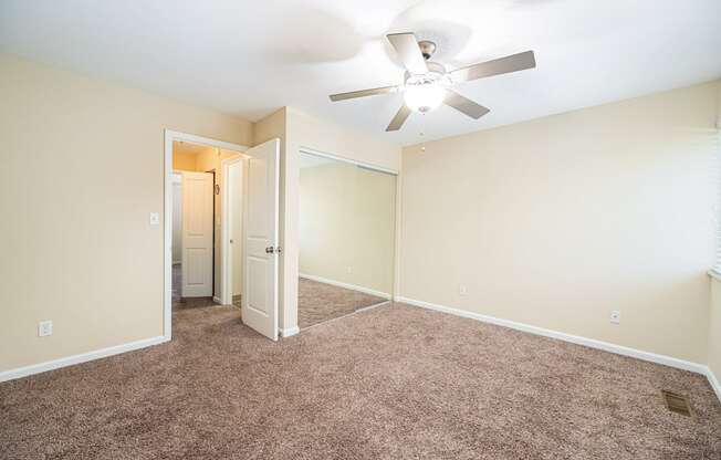 a room with carpet and a ceiling fan