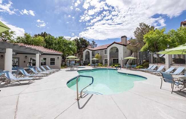 A pool surrounded by lounge chairs and umbrellas.