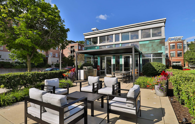 a patio with chairs and tables and a building in the background