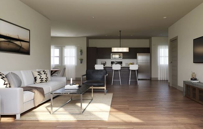 Modern open-concept living room here at 49 West Apartments with a white sofa, abstract art, and a sleek kitchen. Natural light fills the space, creating a cozy, inviting atmosphere.