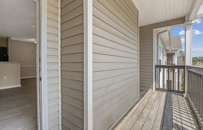 two photos of a porch with white wooden walls and a balcony