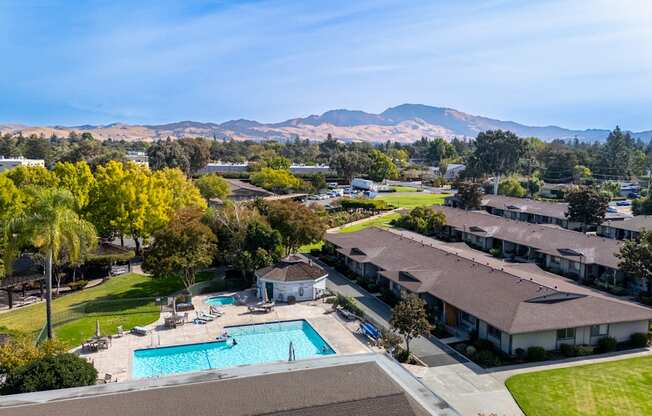 Aerial view of a pool with mountains in the background at The Grove at Walnut Creek Apartments in Walnut Creek, CA.