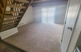 a view from the bottom of the stairs looking into the living room