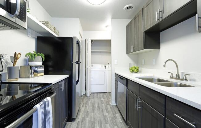 an empty kitchen with a sink and a refrigerator