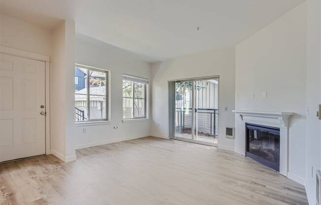 a living room with a fireplace and a door to a balcony