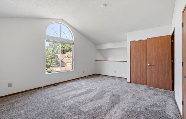 an empty living room with a large window and a door