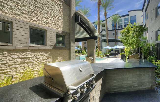 A BBQ grill is in the foreground of a patio area.