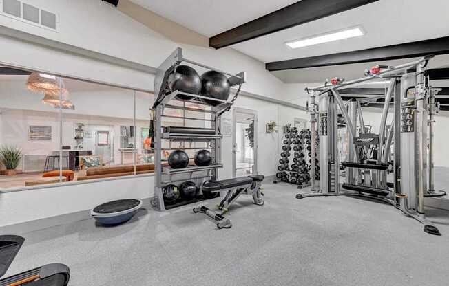 A gym with a variety of equipment including weights and a rowing machine.