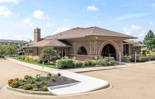 A large building with a brown roof and a parking lot in front.
