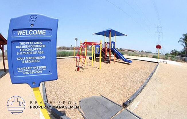 a playground with a blue sign in front of it